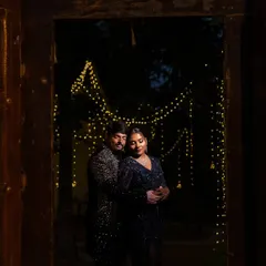 Framed by a rustic doorway, the couple is illuminated by a cascade of fairy lights. This Sangeet portrait is all about creating a moody, romantic, and magical atmosphere.