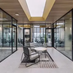 This is a workspace designed for clarity and connection. The design uses glass partitions and open breakout areas to encourage collaboration, while a skylight and neutral tones create a bright, focused atmosphere for the team at RATNAAFIN.
