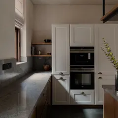 The kitchen at Pràna, a space designed for someone who loves to cook. The combination of classic white cabinetry, warm wood, and durable stone countertops is both beautiful and practical.