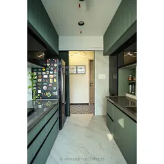 A contemporary kitchen design with sage green cabinetry and a personalized refrigerator door covered in magnets. This space proves that a functional kitchen can also be full of personality.