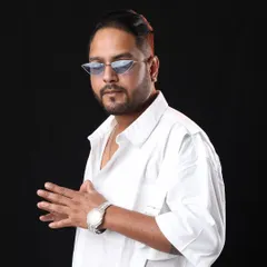 A clean studio shot in a white shirt and cool shades. Sometimes a simple, confident look is all you need.