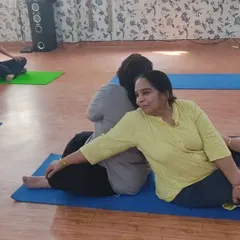 A beautiful partner stretch where one student performs a supported backbend while the other holds a seated twist. This demonstrates the creative and supportive ways we deepen our practice together.