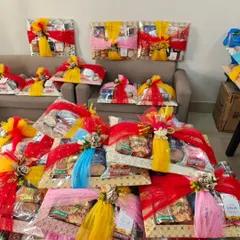 A large order of wedding sagan hampers, wrapped in colorful red, yellow, and blue net, ready to be dispatched.