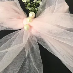 I believe luxury is found in the smallest details. This close-up shows the delicate finishing touches on one of my newborn gift hampers, featuring a hand-tied tulle bow accented with pearls and a sprig of fresh baby's breath.
