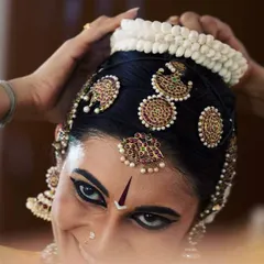 A close up of the traditional head ornaments and makeup for a Bharatanatyam performance. The process of getting ready, or 'aharya abhinaya', is a meditative ritual in itself, helping me transform into the character I am about to portray.