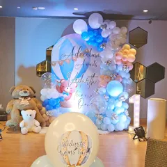 A full view of a vibrant 'Adventure Awaits' first birthday party. This hot air balloon and teddy bear theme shows our detailed work with custom backdrops, elaborate balloon garlands, and marquee lighting.