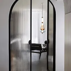 An example of arched doors with ribbed glass panels. This design element adds architectural interest and elegance, perfect for separating spaces without closing them off completely.