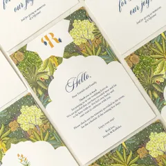 A set of welcome notes and thank-you cards for a wedding with a lush, botanical theme. The arched shape and rich green floral pattern create a warm and inviting welcome for guests.