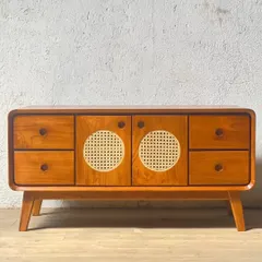 A mid-century modern sideboard made from teak. This piece features a mix of drawers and cabinets with distinctive circular cane panels, offering varied storage options.