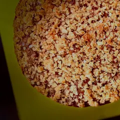 A close-up, top-down view of the apple cinnamon cake, showing the beautiful texture of the buttery coconut oats crumble.