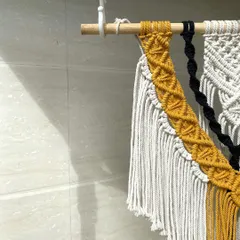 A detailed close-up of the diamond-patterned knotting on our yellow and black macrame wall hanging. This shows the precision and care we put into every single knot.