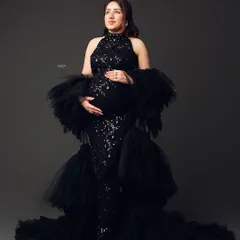 A full-length portrait of a mamma-to-be in a stunning black sequin and tulle gown. This is the epitome of a glam maternity shoot.