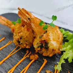 A perfect bite of seafood heaven. The golden panko coating gives way to a punchy chimichurri filling and a juicy prawn, creating a delightful contrast of textures and tastes.