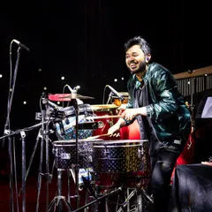 A smile on my face and sticks in my hand during a concert in Raipur with Farhan Live. My setup includes timbales and a dholak to add diverse layers of rhythm.