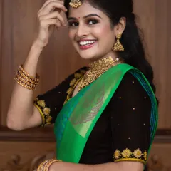 The joy in her smile says it all. This look features a flawless base with a pop of color on the lips, designed to complement the bright green and black saree and make her features shine.