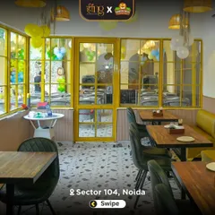 The bright and airy indoor dining section, decorated with yellow window frames and party balloons. It's a cheerful space for a family meal or a birthday feast.