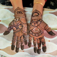 A classic Indian mehendi design filled with traditional elements. One hand features a peacock and lotus, while the other has a jhumka and floral patterns, showcasing a variety of my skills in one set.