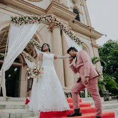 A chivalrous groom kisses his bride's hand on the red carpet leading into the church. This is a timeless, romantic shot.