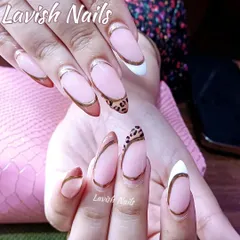 A unique and modern take on the French manicure. This set features almond-shaped nails with a mix of white, copper, and leopard print tips, all outlined with a sharp gold chrome line for a bold, fashionable statement.