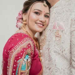 An intimate close-up of the bride on her wedding day. This shot highlights the detailed embroidery on her blouse, her soft and glowing makeup, and the serene expression on her face.