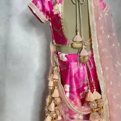 It's all in the details. This pink floral lehenga features a beautifully designed back with delicate ties and an abundance of playful latkans and tassels.