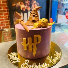 A magical Harry Potter cake for a true Potterhead. This design is topped with an edible Sorting Hat, a magic wand, and a Golden Snitch, all crafted from vegetarian fondant.