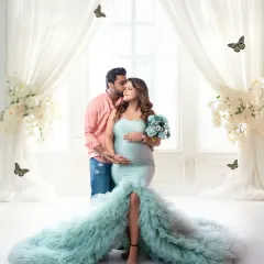 A glamorous maternity portrait for an expecting couple. The flowing sea-green gown and ethereal white drapes create a magical, romantic setting to celebrate the miracle of life.