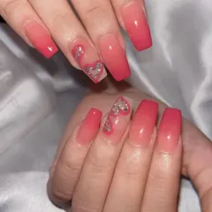 A beautiful pink ombre set with a special touch. The accent nail features a negative space heart filled with glitter, adding a playful and romantic element to the classic gradient look.