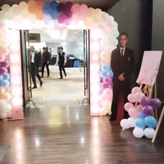 Guests walking through the lit balloon archway. This view shows how the entrance serves as a perfect transitional piece from the reception area into the main event hall.