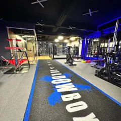 A wide shot of our studio floor, featuring the custom Shadowbox turf track that's perfect for sled pushes, agility drills, and more. In the background, you can see our boxing ring and strength training area.