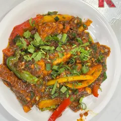 Our plated Chicken Sizzler, a delicious mix of juicy chicken and colourful bell peppers tossed in a thick, spicy sauce and garnished with fresh herbs.