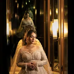 A creative portrait using reflections to create an infinity effect. The bride, in her magnificent reception gown, looks like a queen in a hall of mirrors.