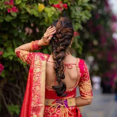 A stunning and intricate bridal braid, woven with pearls. This hairstyle is perfect for a South Indian bridal look or for any bride who wants a unique and elegant style.