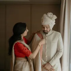 A behind-the-scenes moment of the groom getting ready, with his mother adjusting his stole. We style grooms in a variety of silhouettes, from classic dhotis to elegant sherwanis like this one.