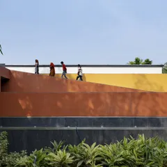 The exterior of the Vismaya museum is a composition of bold, simple forms articulated in different colors and textures. This approach breaks down the building's mass and responds to the surrounding landscape and internal display requirements.