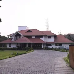 We also undertake large-scale projects like this estate house in Thrissur for Mr. Alex. The design balances a grand scale with traditional architectural forms, including sloping tiled roofs and deep verandas, creating a stately yet welcoming family home.