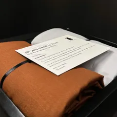 A closer look inside one of our bespoke gift boxes. This set includes premium fabric for a custom shirt and trouser, accompanied by a personal note, offering the recipient a complete outfitting experience.