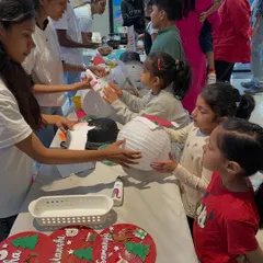 This is a typical scene at one of my workshops. Children are gathered around the table, fully engaged in making their own Christmas lanterns. My team and I are always there to guide and assist them.