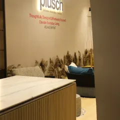 A glimpse into the booth's interior, where the brand's tagline is displayed. The design uses natural elements like pampas grass to soften the space and complement the luxurious furniture on display.
