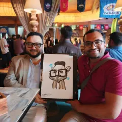 Two colleagues enjoying their caricature at the Coleda Private Limited annual party. It's a great team-building activity that sparks conversation and laughter.