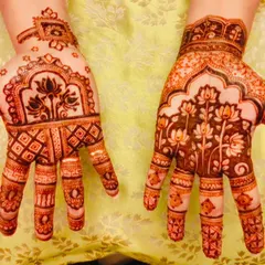 A beautiful mother-daughter duo showing off their matching Diwali henna. The designs feature intricate lotus motifs, a symbol of purity and beauty, perfect for the festival of lights.