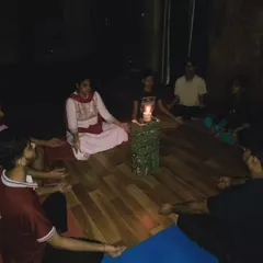 Students sit in a circle, focusing their gaze on the candle flame. This shared meditative experience builds a calm and focused energy within the group.
