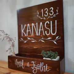 We love combining beauty with function. This custom wooden name plaque, "Kanasu," which means 'dream,' features a built-in planter box, adding a touch of green life to a family's entrance.