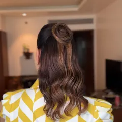 A back view of the stylish half-up top knot I created for Aastha. It's a trendy and effortless look that's perfect for any event.