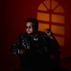 A stylish, low-key portrait of the groom in a sequined tuxedo, using creative lighting for a dramatic effect.