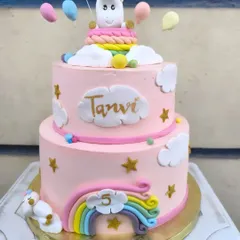 A magical two-tier unicorn cake for a very special 5th birthday. This pink cake features a cute fondant unicorn, rainbows, clouds, and stars, creating a dreamy centerpiece for a fantasy-themed party.