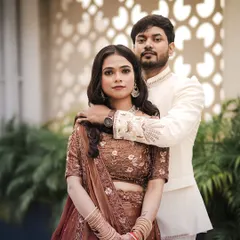 A classic portrait of the engaged couple. The groom's hand on the bride's shoulder creates a sense of intimacy and connection, set against a modern architectural backdrop.
