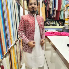A client trying on a red and white embroidered open jacket in my studio. The fit is tailored to be comfortable yet sharp.