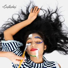 This creative portrait captures the process of art itself. The overhead perspective and the act of painting on the face create a unique and engaging image, perfect for an artistic or editorial portfolio.