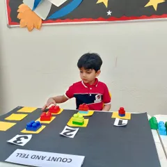 Math becomes a fun puzzle to solve with our "Count and Tell" block activity. Here, a young student is focused on matching the number of colorful blocks to the corresponding numeral, building a strong foundation for number recognition and counting skills.